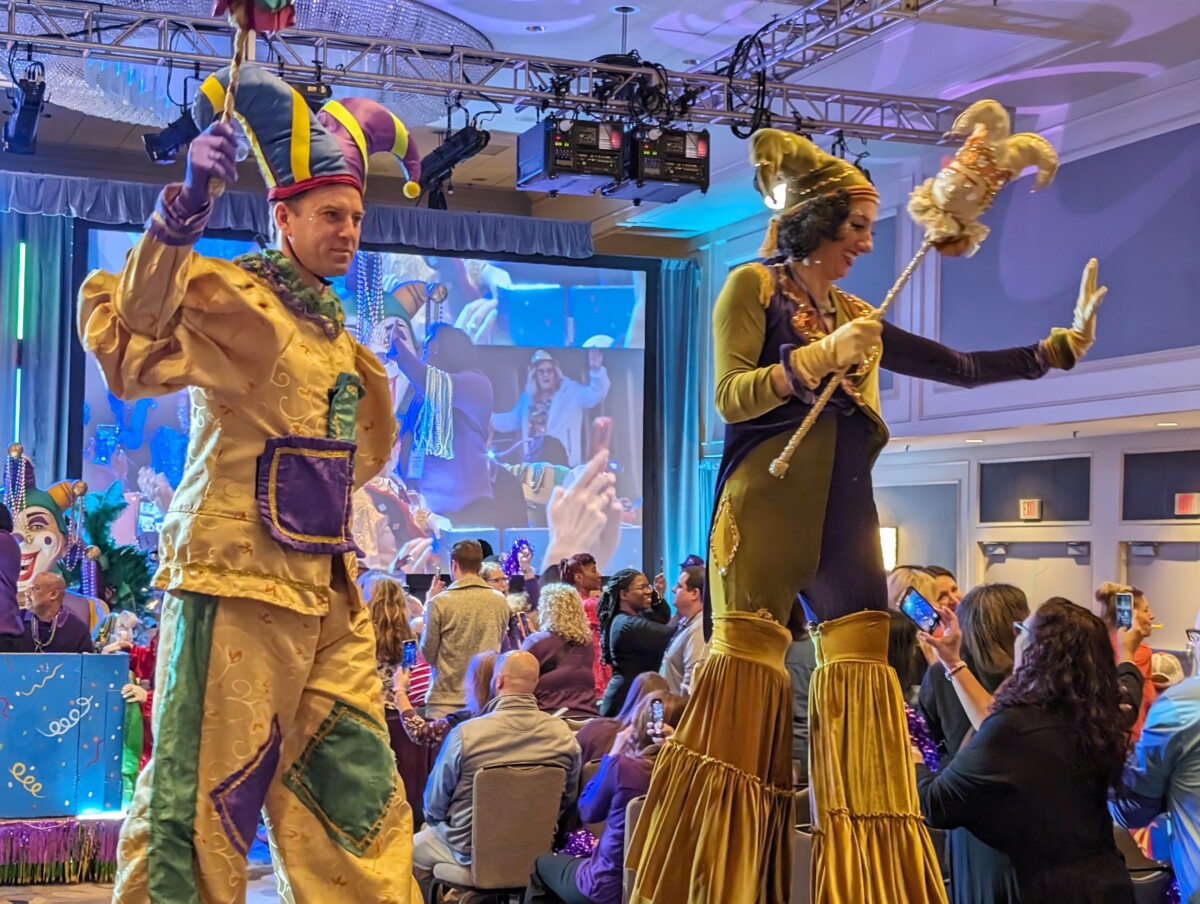 A man and women dressed up as a jester on a stage